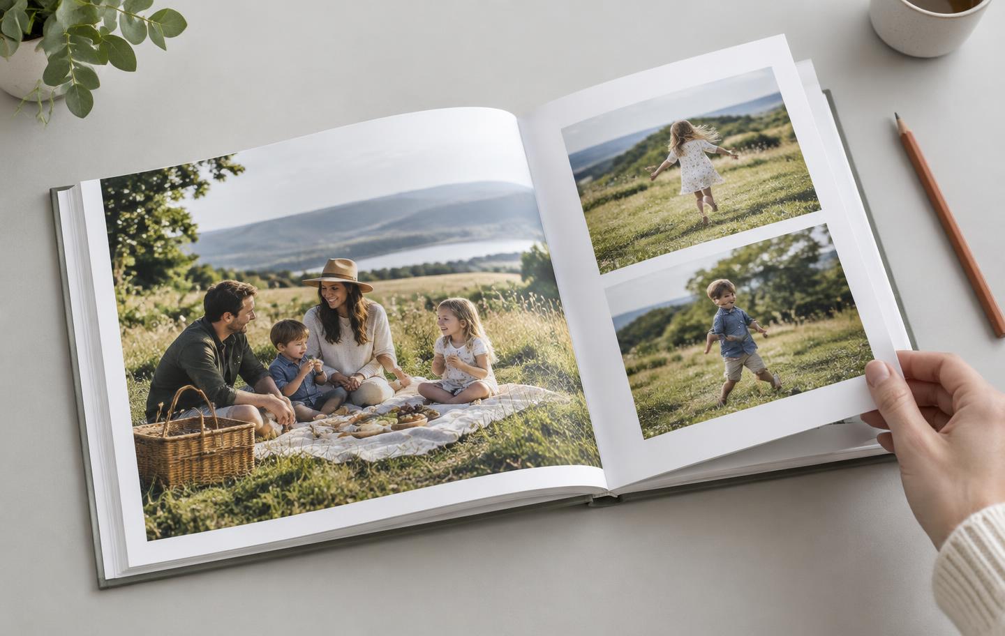 Fotolibro aperto con un picnic di famiglia e due foto di bambini, mentre una mano gira la pagina